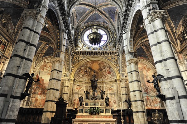 Black and white striped marble columns in the cathedral, cross and round arches, Siena, Tuscany,