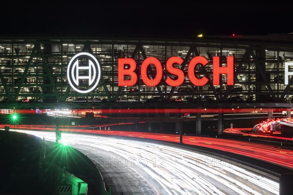 A8 motorway at Stuttgart Airport with Bosch multi-storey car park in the evening, cars create light