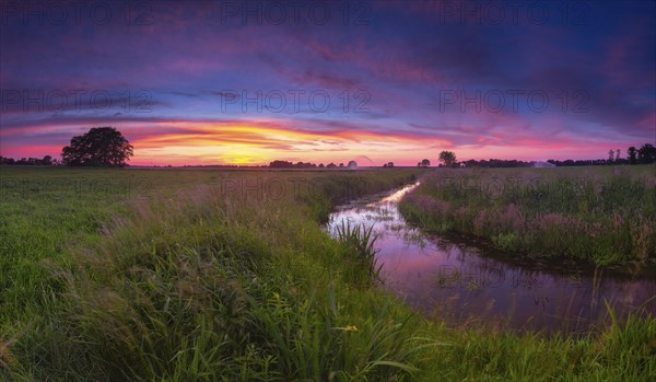 Landscape photo of a moat at sunset, wind, landscape format, evening light, landscape photography,