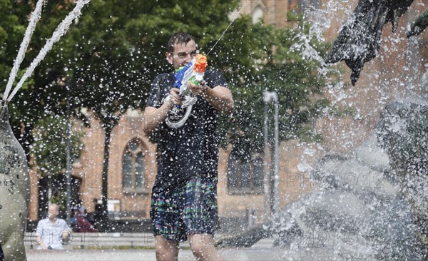 Participants in the annual water fight at Berlin's Neptune Fountain cool off in summer