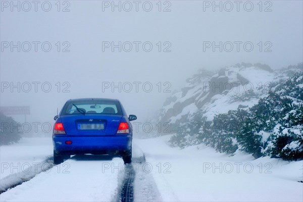 Blue rental car in the snow of the highest mountain Roque de los Muchachos altitude 2400 m, La