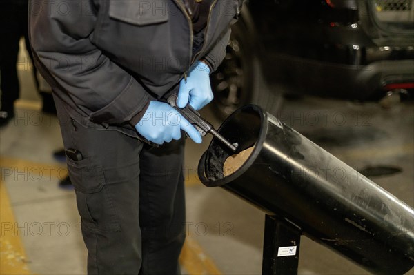 Detroit, Michigan, A police officer checks a handgun turned in at a gun buy-back event to be sure