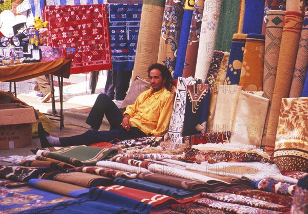 Resting carpet seller at market in Torre del Mar, Andalusia, Spain, Southern Europe. Scanned