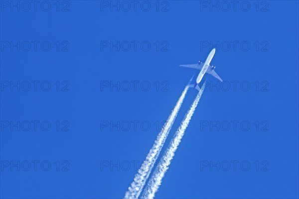 Flying twin-engine jet airliner, aircraft, plane from the airline Kuwait Airways showing contrails,