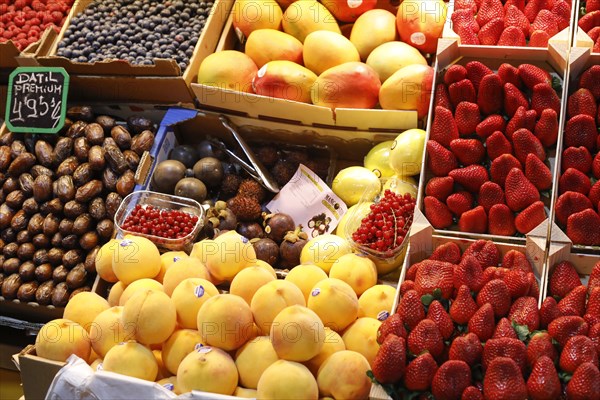 Fresh strawberries, mangoes, dates, peaches, blueberries and redcurrants at the fruit and vegetable