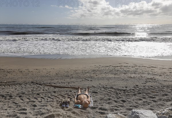 A man sunbathes on the deserted beach of Torremolinos, Spain, Costa del Sol, 13/02/2019, Europe