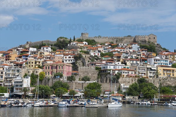 A marina with colourful houses and an ancient castle under a partly cloudy sky, fortress, old town,