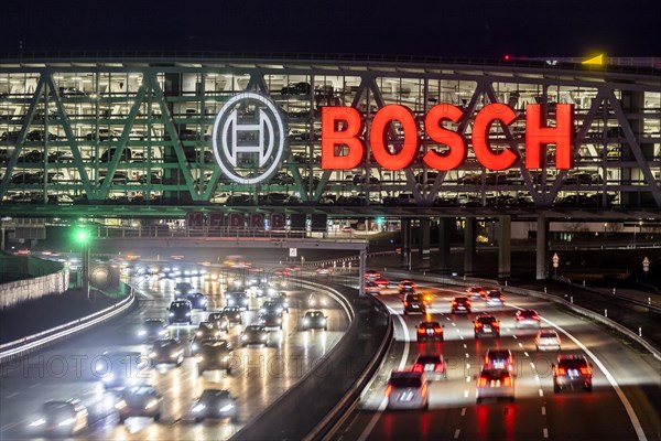 A8 motorway at Stuttgart Airport with Bosch multi-storey car park in the evening, cars create light