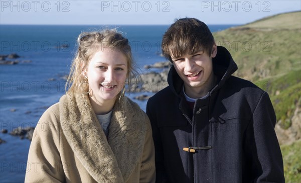 Model released brother and sister twins standing together on sunny winter day, Cornwall, England,