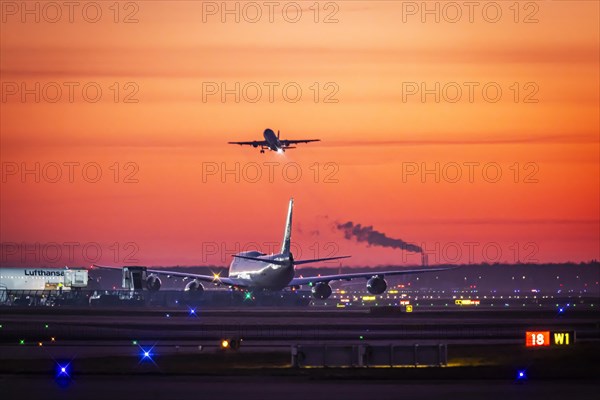 Early in the morning at the airport in front of sunrise, a Boeing 747 aircraft stands ready for