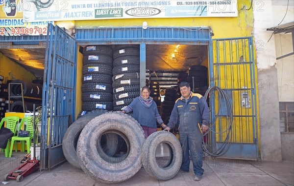 Peruvian couple, 38 and 45 years old, showing tyres from their tyre workshop, Palccoyo, Checacupe