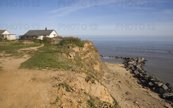 Cliff top buildings at risk of coastal erosion, Happisburgh, Norfolk, England with beach rock