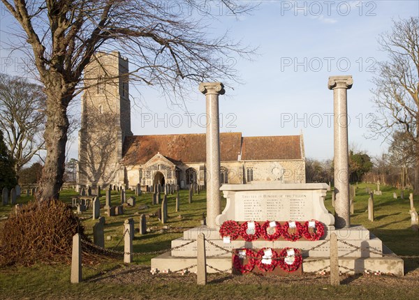 War memorial with poppy wreaths at St John the Baptists church, Snape, Suffolk, England, United
