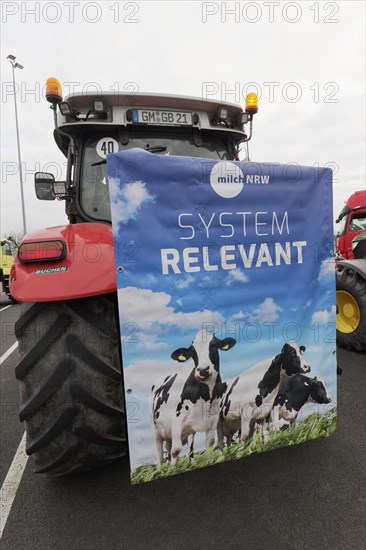 Poster with dairy cows and writing Systemrelevant on a tractor, farmer protests, demonstration