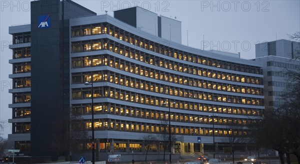 AXA insurance office illuminated by electric lights in winter afternoon, Ipswich, Suffolk, England,