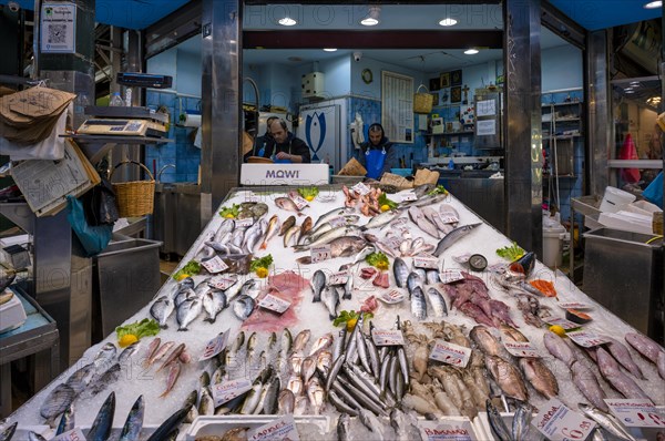 Trader, fishmonger working in his market stall, display of fresh fish and seafood on ice, Food,