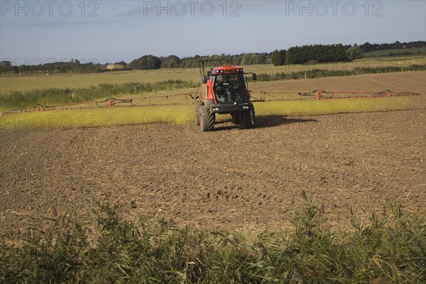 Farm machinery spraying Glyphosate herbicide on an arable field near Hollesley, Suffolk, England,