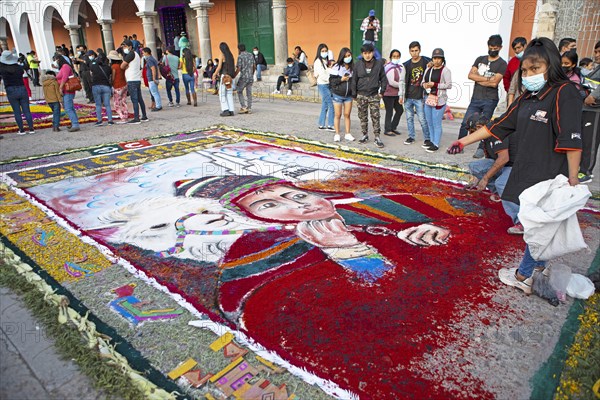 Peruvian woman making a floor painting in the Plaza de Armas, spectators watching, Ayacucho,
