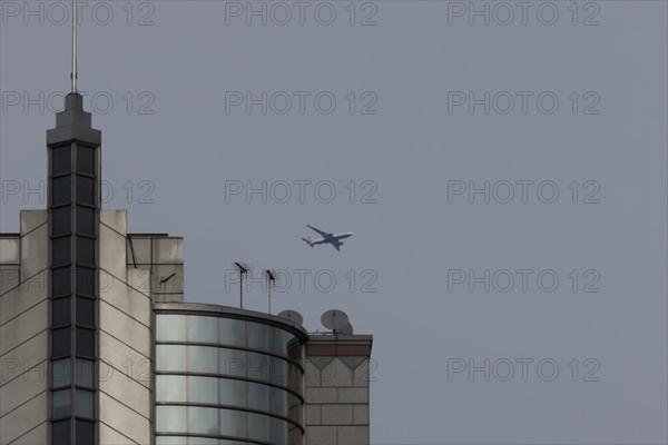 Airbus A319-100 aircraft of British airways in flight over a city skyscraper building, London,