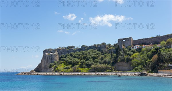 View of a sunny coastal landscape with blue sea, historic ruins and lush vegetation, Byzantine