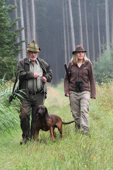 Huntsman and huntress, accompanied by hunting dog Bavarian Mountain Hound, Allgaeu, Bavaria,