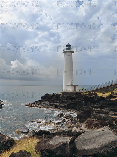 White lighthouse on a steep coast. Dramatic clouds with a view of the sea, pure Caribbean at Le