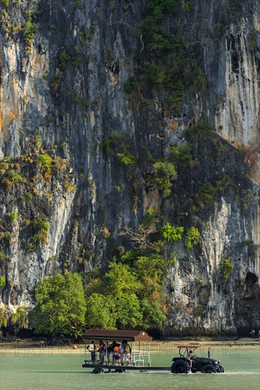 Tractor for transporting tourists in front of limestone rocks at Railay Beach, transport,