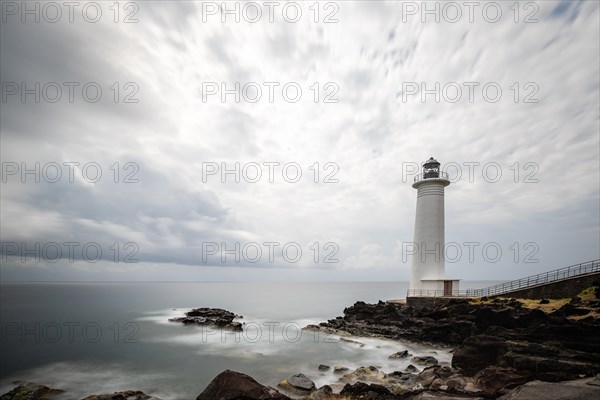 White lighthouse on a steep coast. Dramatic clouds with a view of the sea, pure Caribbean at Le