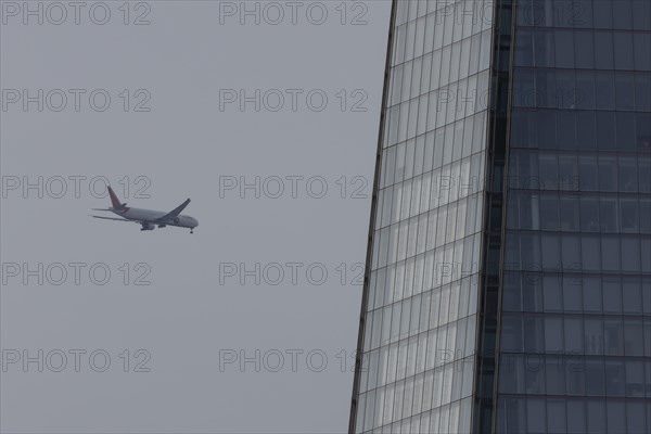 Aircraft of Air India airways in flight over The Shard city skyscraper building, London, England,