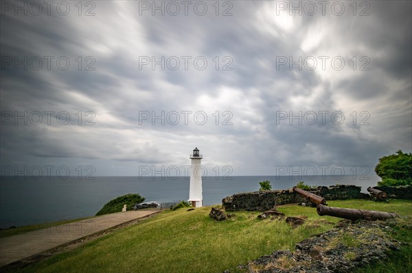 White lighthouse on a steep coast. Dramatic clouds with a view of the sea, pure Caribbean at Le