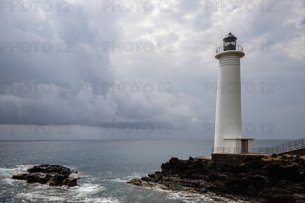 White lighthouse on a steep coast. Dramatic clouds with a view of the sea, pure Caribbean at Le