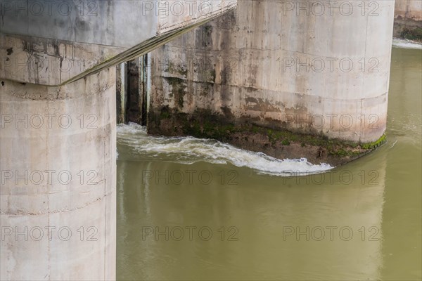Algae and moss on a concrete bridge structure show signs of water flow and erosion, in South Korea
