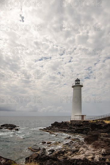 White lighthouse on a steep coast. Dramatic clouds with a view of the sea, pure Caribbean at Le