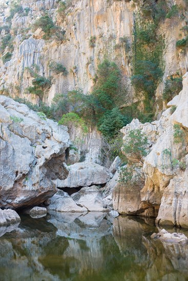 Torrent de Pareis, calm water surface in a riverbed of a mountain stream surrounded by impressive,