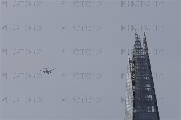 Airbus A319-100 aircraft of British airways in flight over The Shard city skyscraper building,