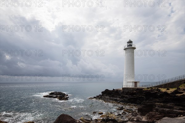 White lighthouse on a steep coast. Dramatic clouds with a view of the sea, pure Caribbean at Le