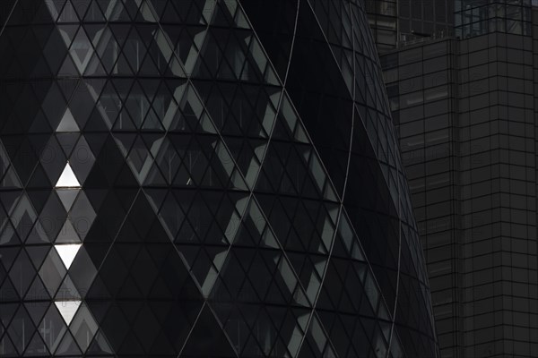 The Gherkin skyscraper building close up of window details with sunlight illuminating three