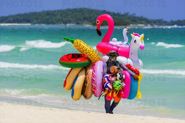 Merchant on the beach selling inflatable swimming aids, colourful, swimming, beach vendor, holiday,