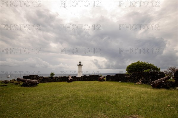 White lighthouse on a steep coast. Dramatic clouds with a view of the sea, pure Caribbean at Le