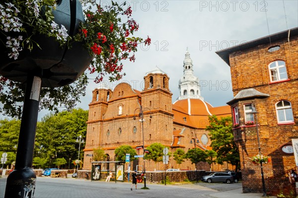 Panorama of Nikiszowiec brick architecture with flowers in the foreground in focus, Katowice,