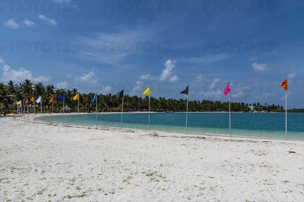 White sand beach with many flags, Bangaram island, Lakshadweep archipelago, Union territory of