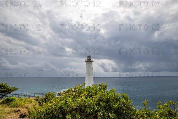 White lighthouse on a steep coast. Dramatic clouds with a view of the sea, pure Caribbean at Le