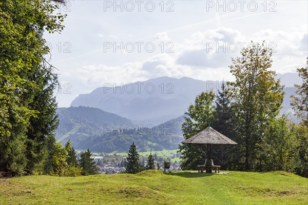 Wetterstein mountains with forest and shelter with benches, in autumn, hiking trail