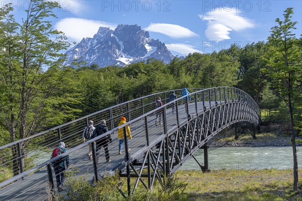 Tourists walk across a bridge over a tributary of Lago Grey, Torres del Paine National Park, Parque