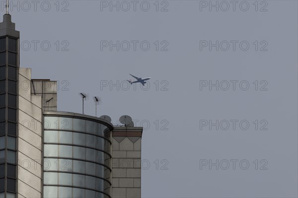 Airbus A319-100 aircraft of British airways in flight over a city skyscraper building, London,