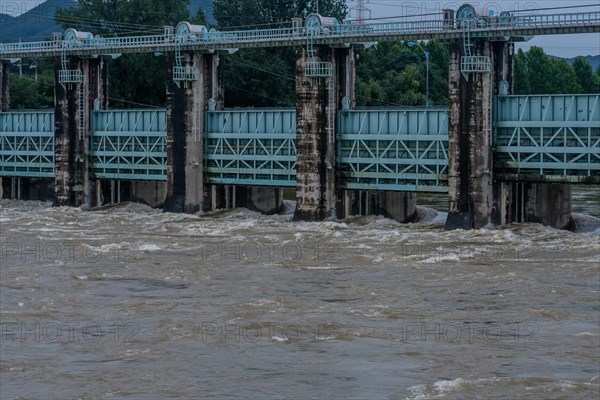Dam with water surging through open floodgates after torrential monsoon rains in Daejeon South