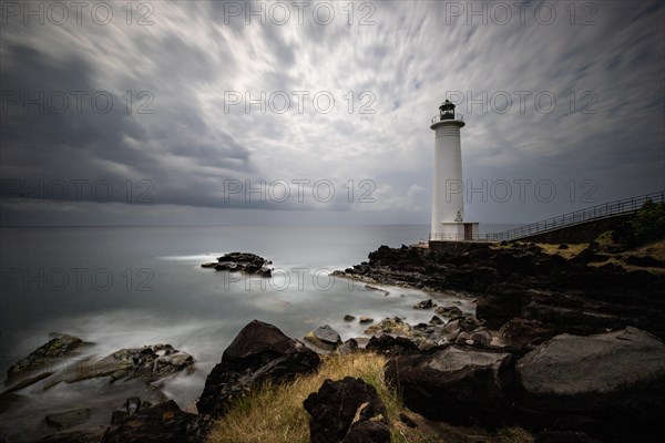 White lighthouse on a steep coast. Dramatic clouds with a view of the sea, pure Caribbean at Le