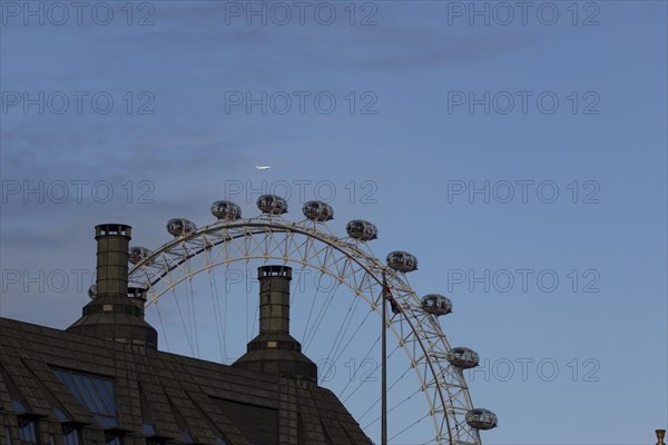 Airbus A319-100 aircraft of British airways in flight over the pods of the London Eye or Millennium