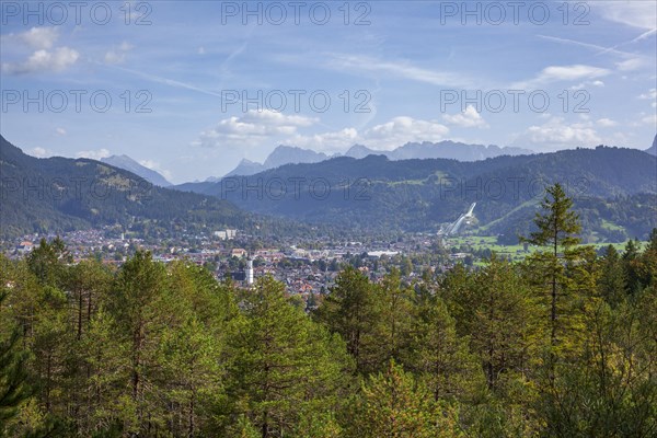 Overview of Garmisch-Partenkirchen with Karwendel mountains and forest in autumn, hiking trail