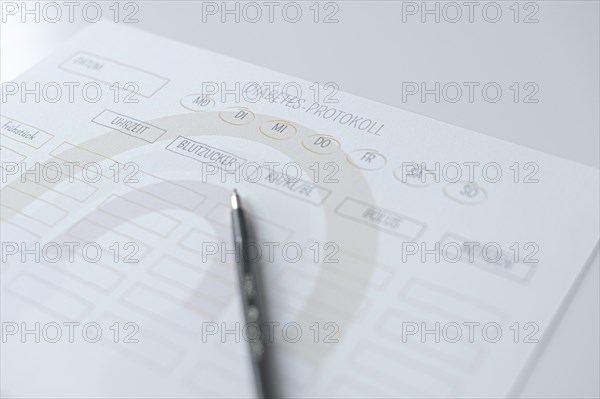 Diabetes log, daily log of food and insulin administration, food log, the paper lies on a white